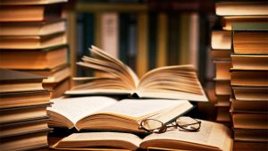 stacks of books with one fanned open in front